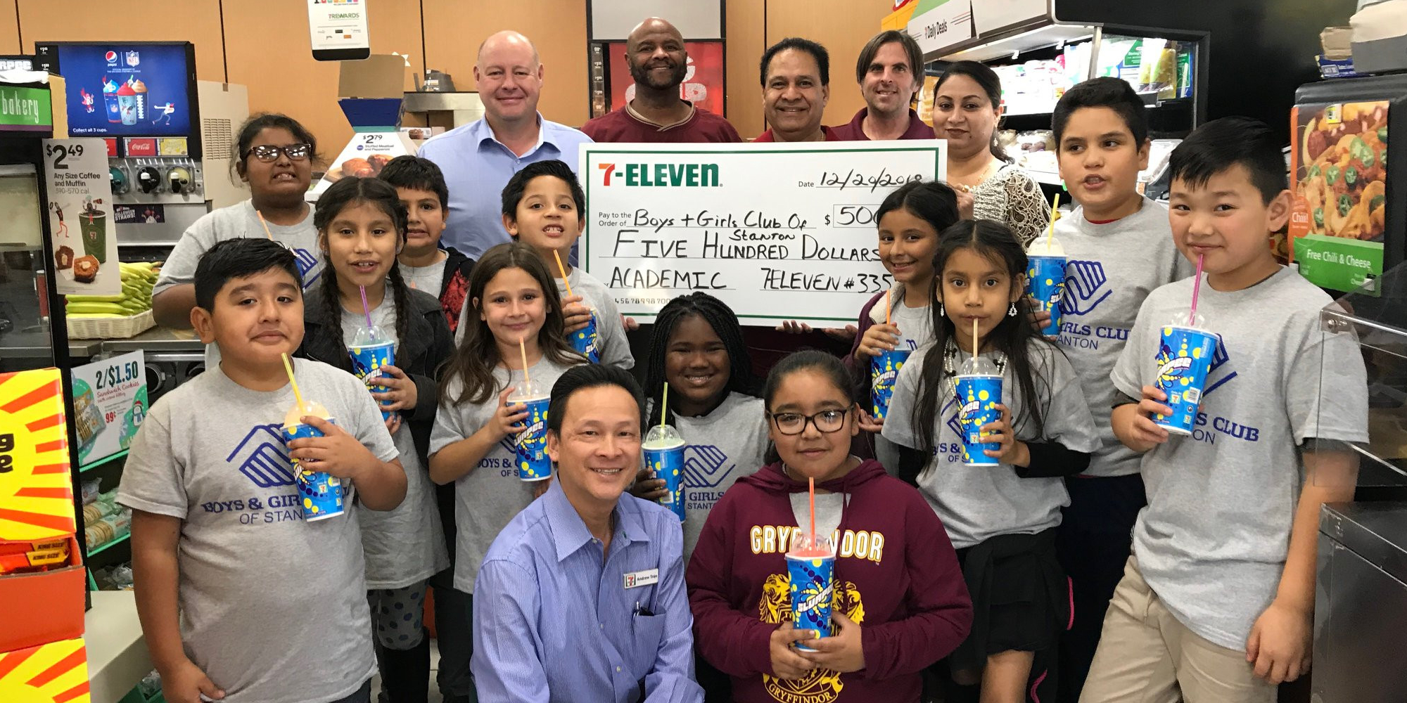 Group of students at 7-eleven holding a large $500 dollar check